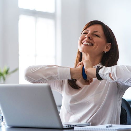debt-relief happy debt relief client smiling and sitting at her desk