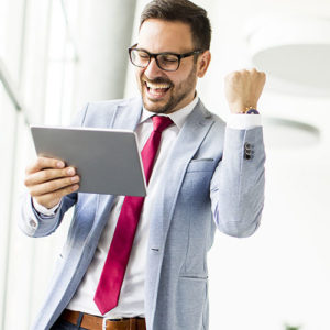 businessman celebrating debt consolidation and holding an iPad