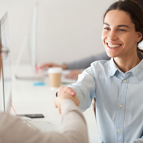 student-loan female student smiling and shaking someone's hand during debt relief discussion