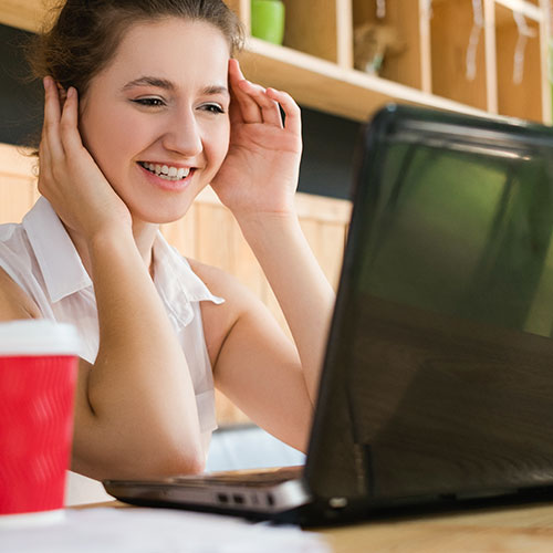 a woman looking at her laptop and smiling