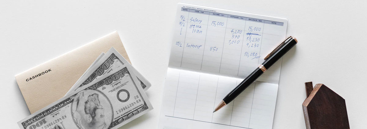 a checkbook and cash on a table