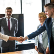 teams shaking hands at a meeting