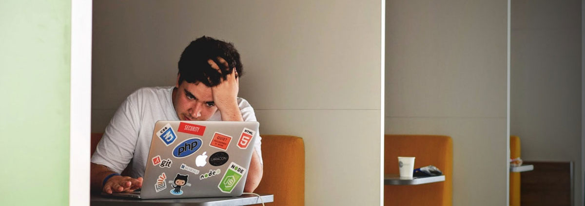 stressed man sitting at his laptop